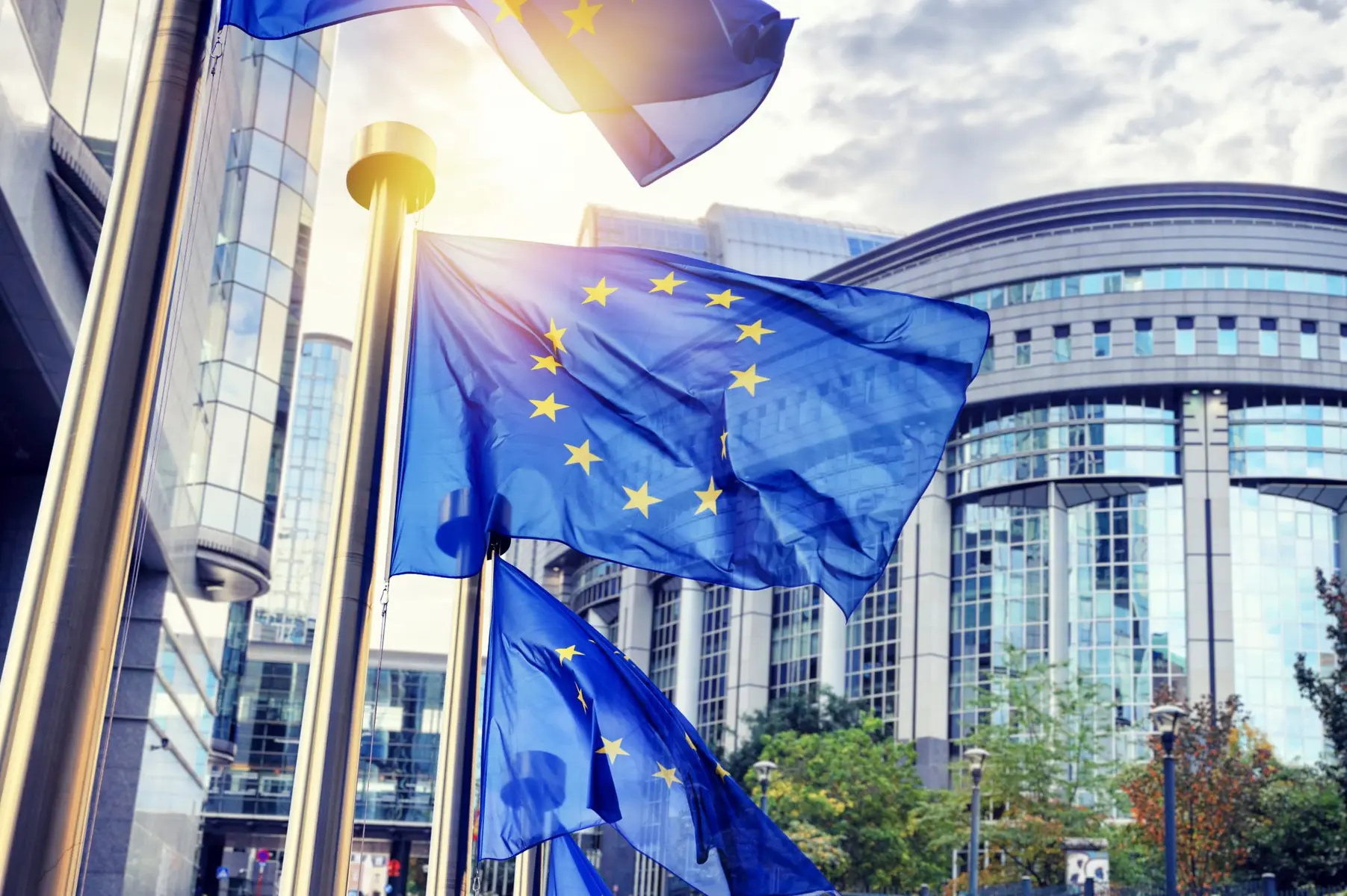 European Union flags waving in front of the European Parliament building in Brussels