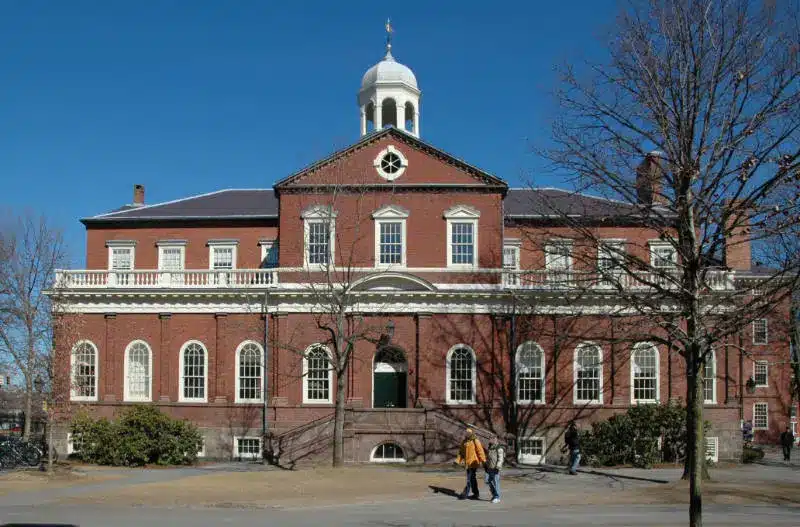 The red brick facade of Sanders Theatre at Harvard University with a white dome and cupola under a blue sky