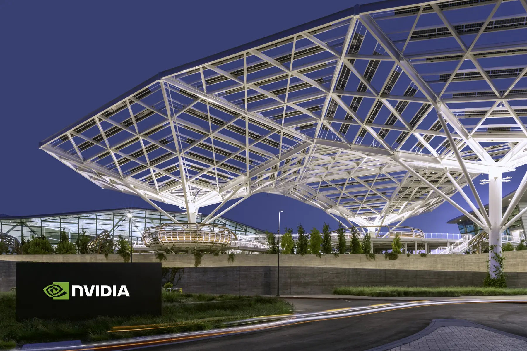 NVIDIA headquarters featuring a futuristic white geometric canopy structure and company signage at dusk.