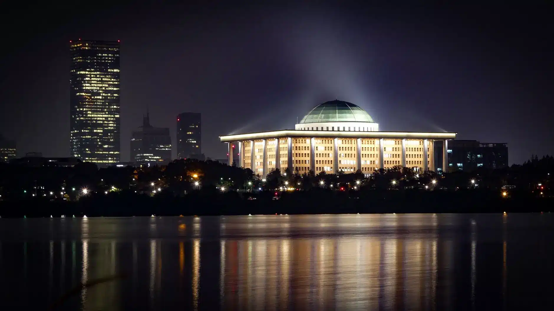 Night view of the South Korea National Assembly building with its illuminated dome reflecting in the water
