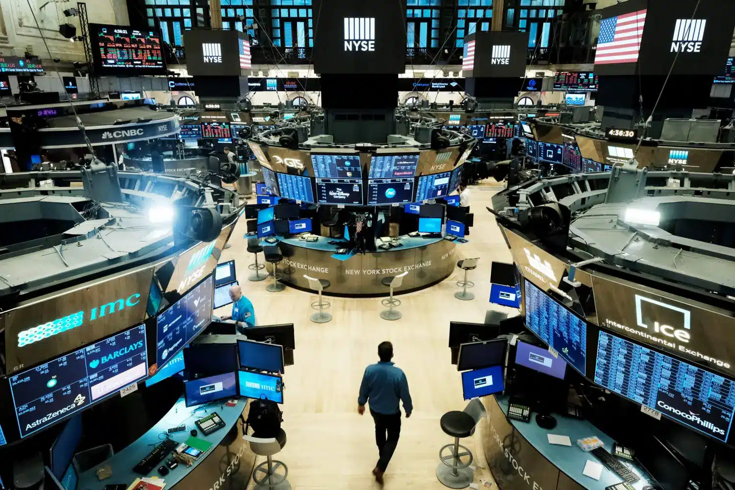Traders and monitors on the New York Stock Exchange trading floor with NYSE branding and American flag