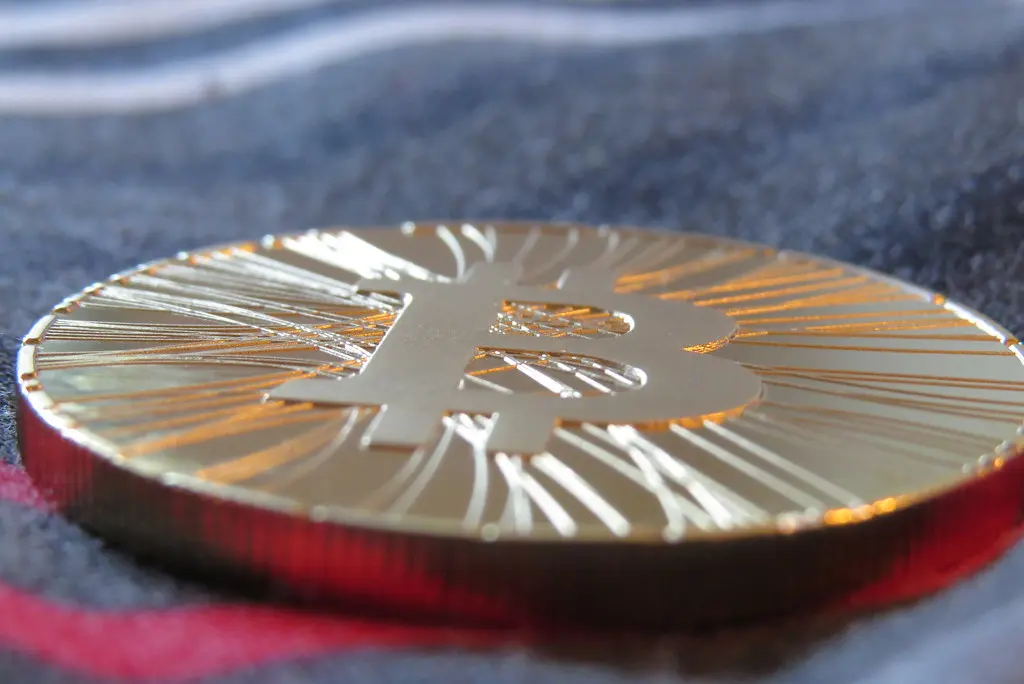 Nahaufnahme einer physischen goldfarbenen Bitcoin-Münze.