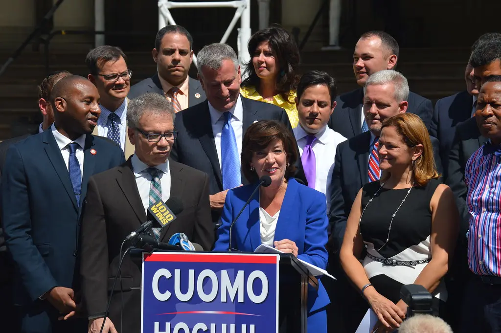 Kathy Hochul spricht an einem Podium neben anderen Personen.